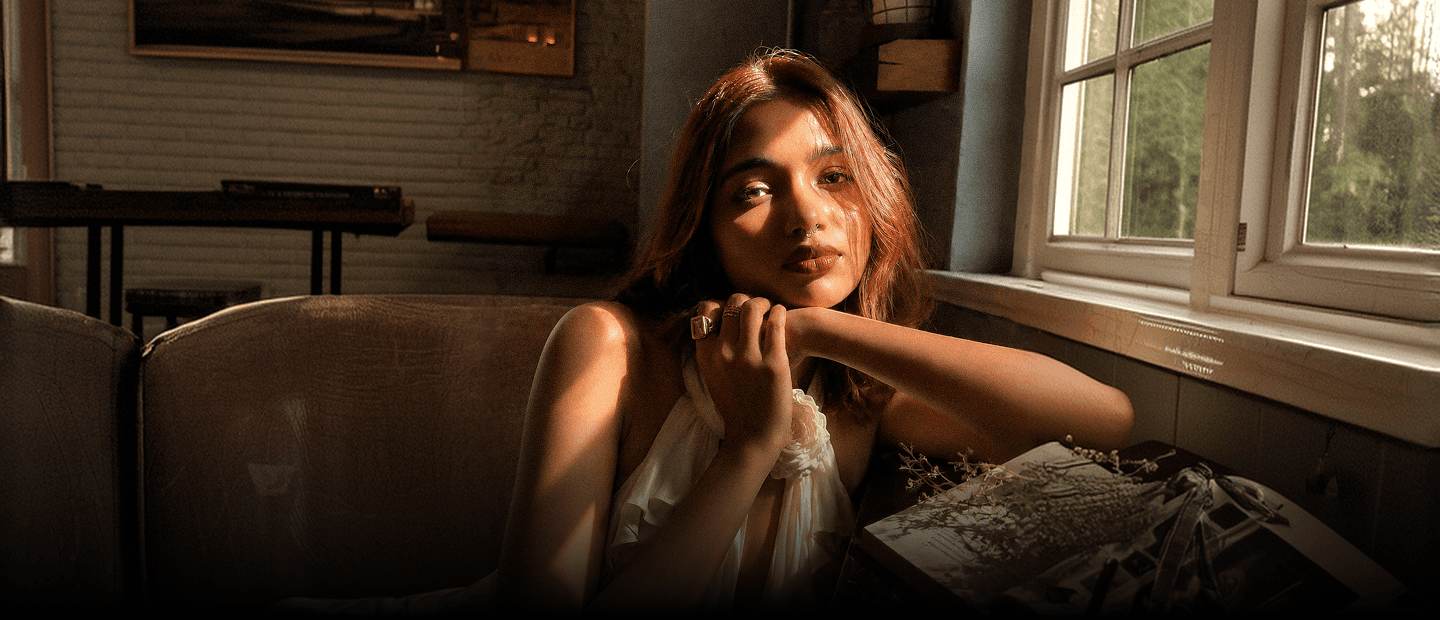 Smrithi resting her chin on her hands in warm window light